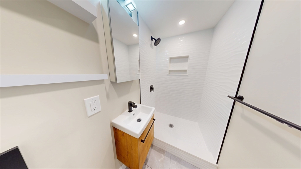 31-35 India Street, Unit 202 Boston, MA 02109 - Photo 5 of 5 a bathroom with a tub sink and mirror