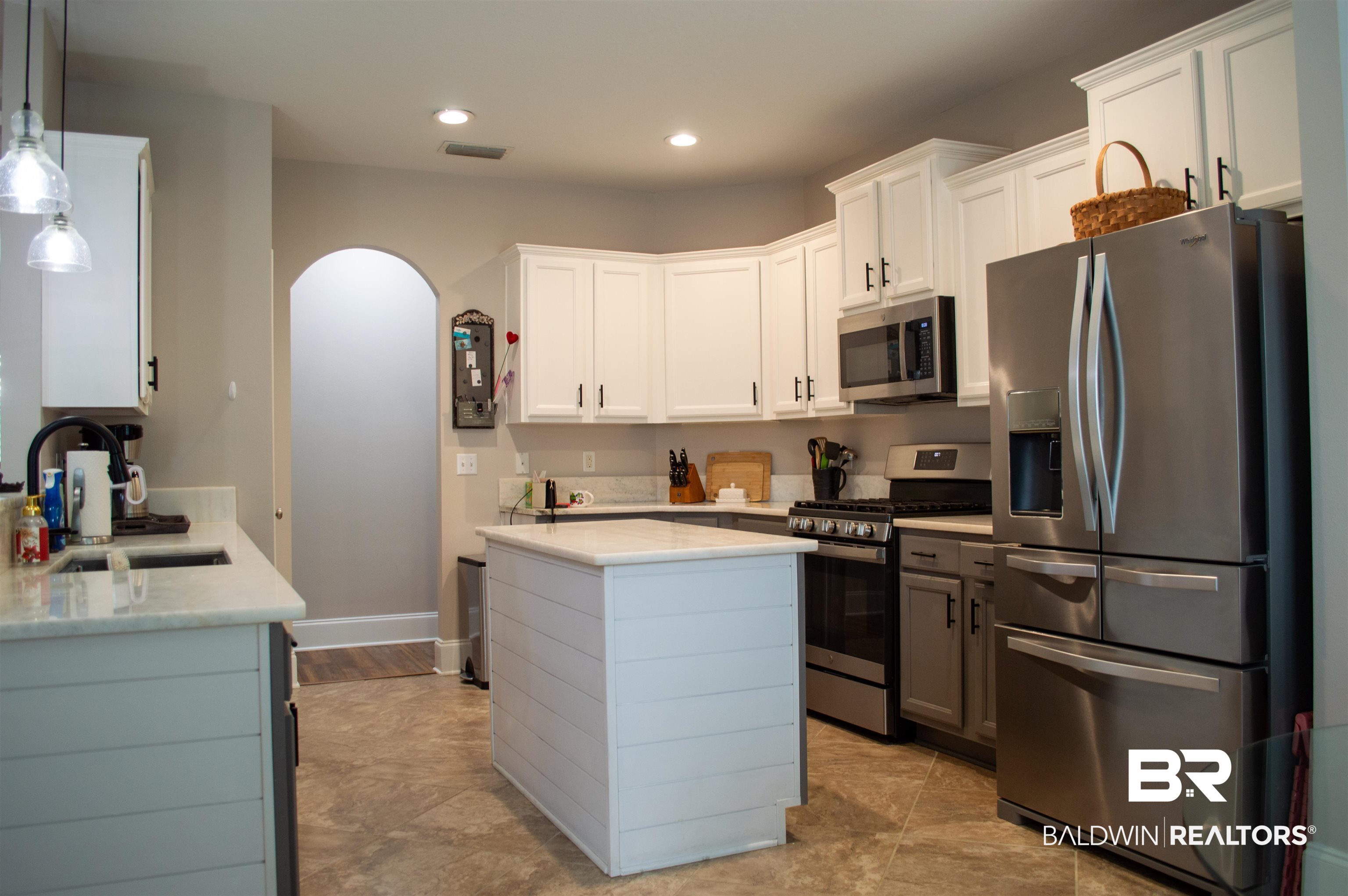 1124 West Orlando Drive Foley, AL 36535 - Photo 12 of 51 Kitchen with stainless steel appliances, arched walkways, pendant lighting, light stone counters, and a center island