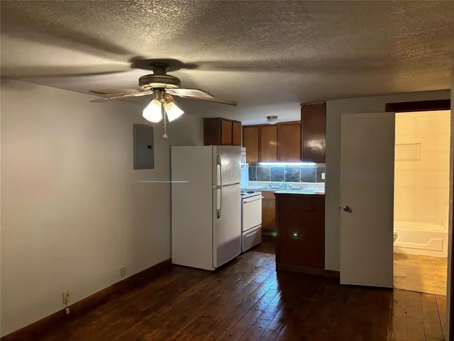 a kitchen with stainless steel appliances granite countertop a refrigerator a sink a stove a microwave and island with wooden floor