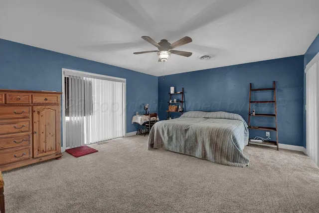 a spacious bedroom with a bed and a chandelier