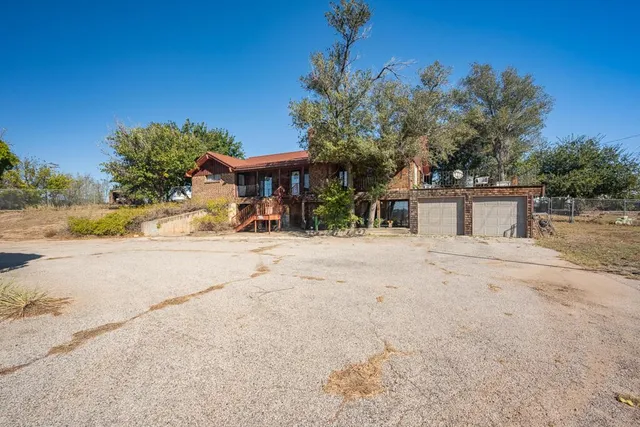 a view of backyard with seating space and wooden fence