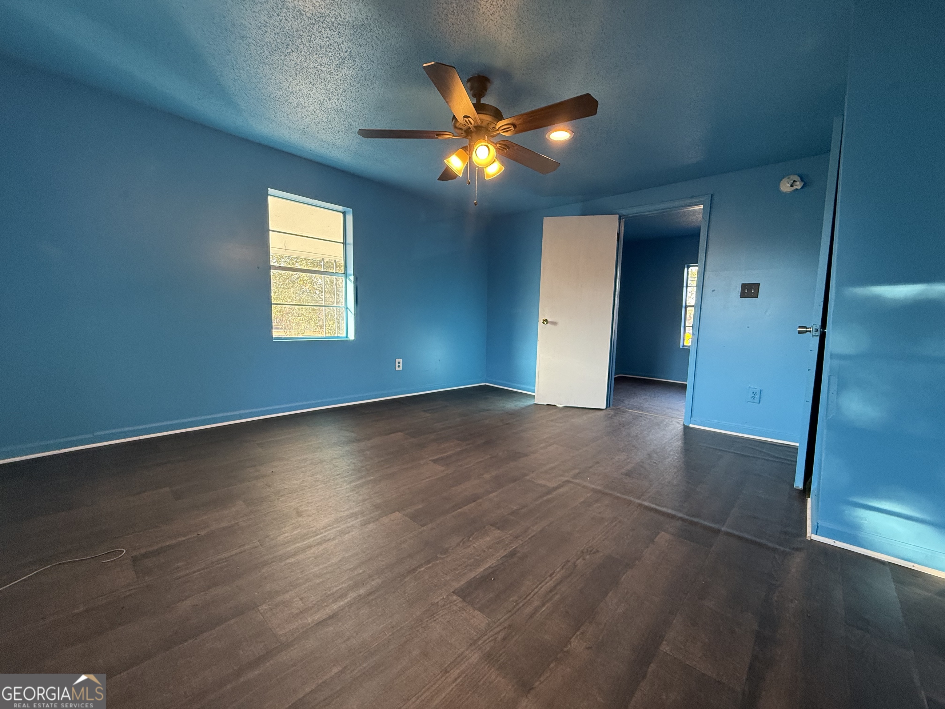 803 Pine Street Fort Valley, GA 31030 - Photo 14 of 22 an empty room with wooden floor and windows