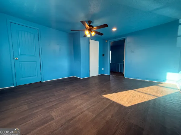 a view of empty room with wooden floor