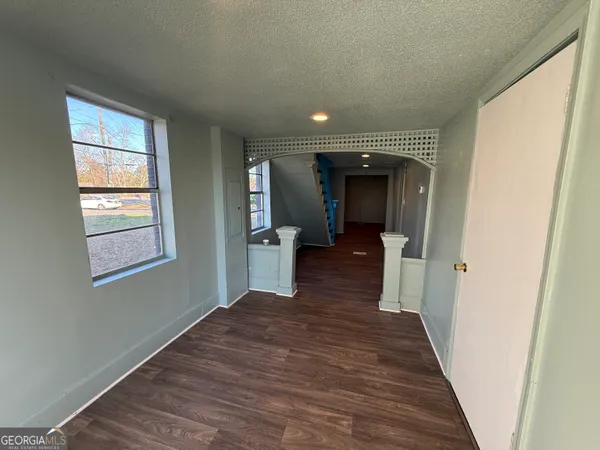 a view of a hallway with wooden floor and a living room
