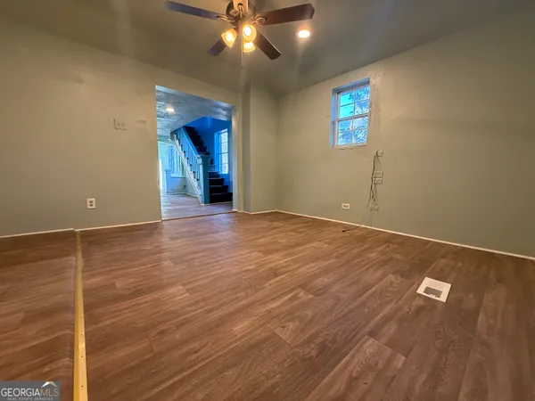 an empty room with wooden floor and windows