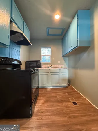 a kitchen with granite countertop a sink cabinets and stainless steel appliances