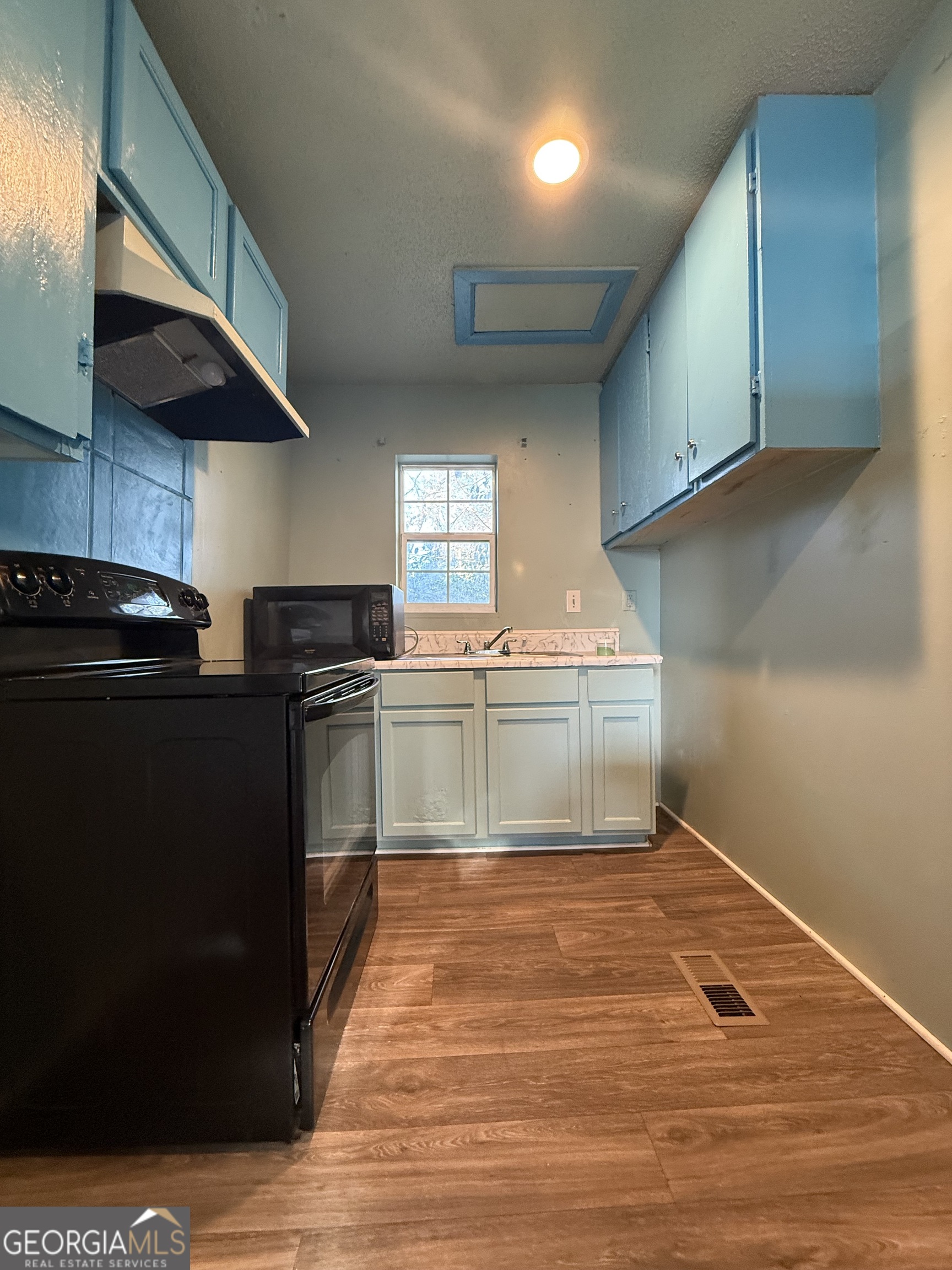 803 Pine Street Fort Valley, GA 31030 - Photo 10 of 22 a kitchen with granite countertop a sink cabinets and stainless steel appliances