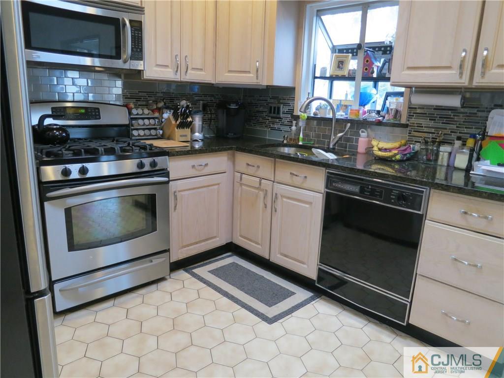 6 Colburn Road East Brunswick, NJ 08816 - Photo 6 of 24 a kitchen with stainless steel appliances granite countertop a stove a sink and a microwave