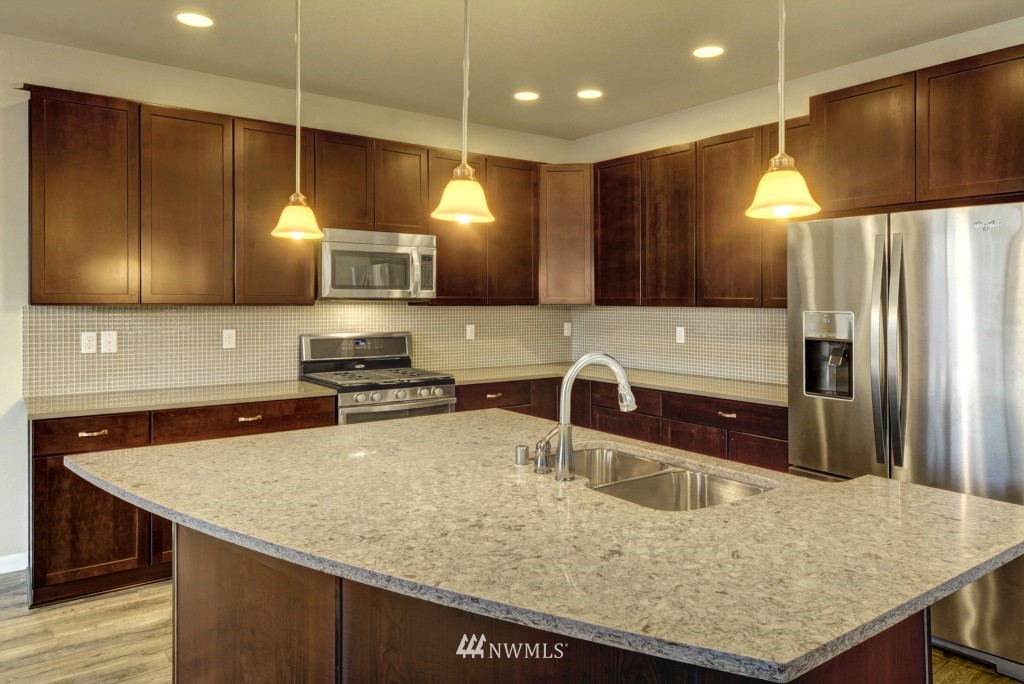 3601 176th Place Southeast, Unit 2009 Bothell, WA 98012 - Photo 4 of 19 a kitchen with stainless steel appliances granite countertop a sink a stove and a refrigerator