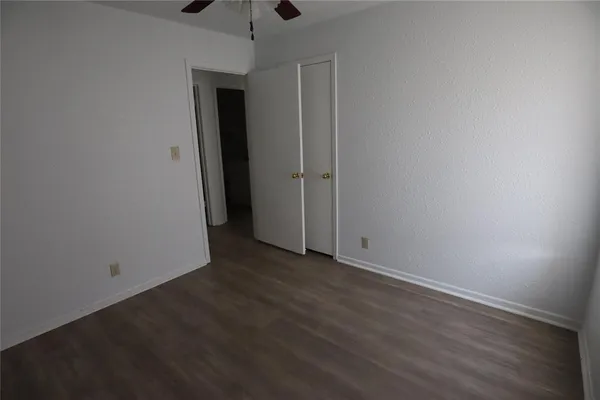 an empty room with wooden floor and closet