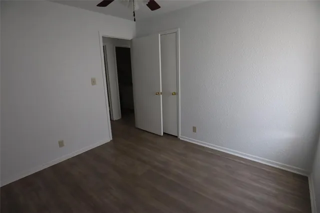 an empty room with wooden floor and closet