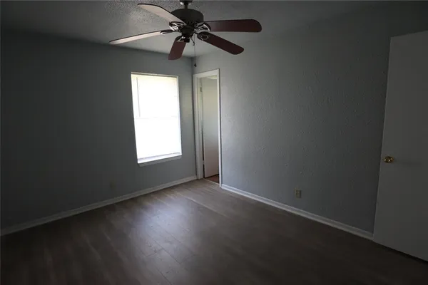 an empty room with a window and a fan