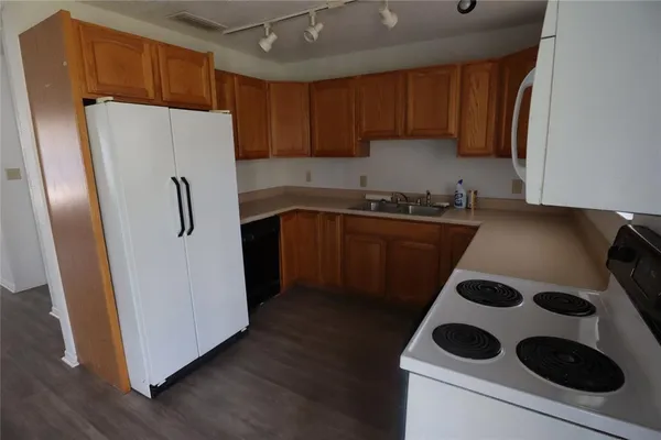 a kitchen with a refrigerator sink and cabinets