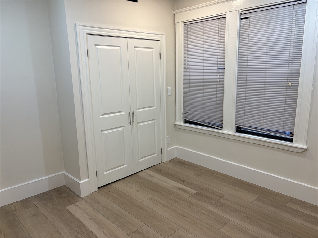 1672 Beacon Street, Unit 2A Brookline, MA 02445 - Photo 3 of 4 an empty room with wooden floor