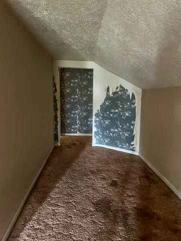 a view of a big room with wooden floor and windows