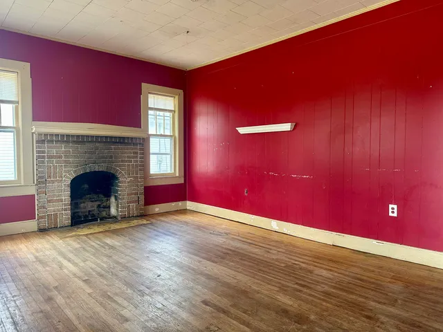 a view of empty room with wooden floor and fireplace