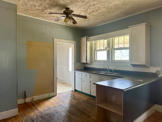 a kitchen with stainless steel appliances granite countertop a sink cabinets and wooden floor