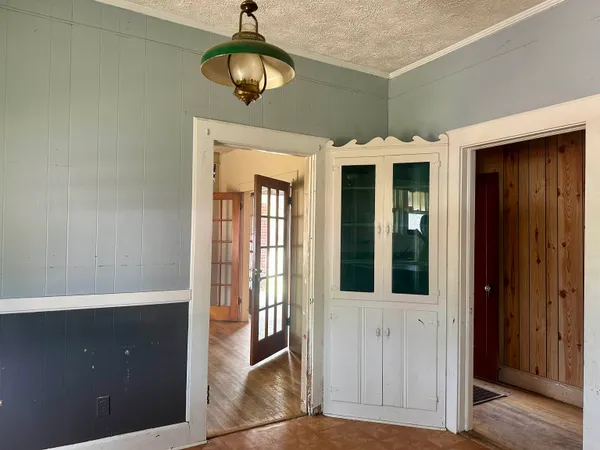 a view of a hallway with wooden floor and chandelier