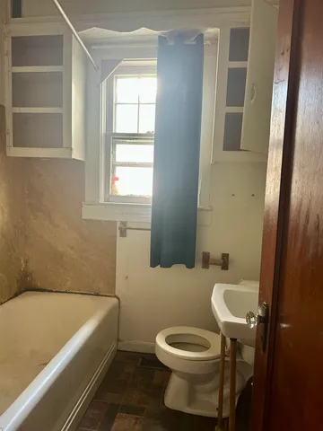 a bathroom with a sink and bathtub with toilet