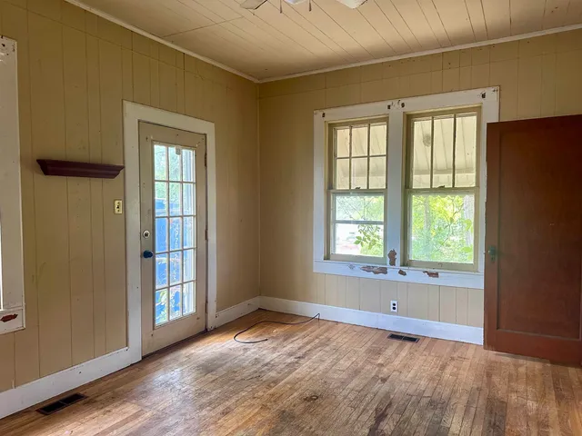 a view of a bedroom with wooden floor and a window