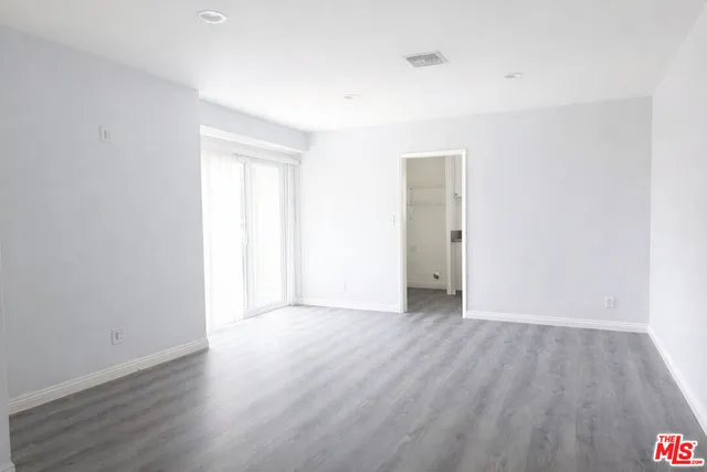 an empty room with wooden floor and closet