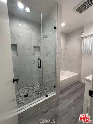 a bathroom with a bathtub and shower