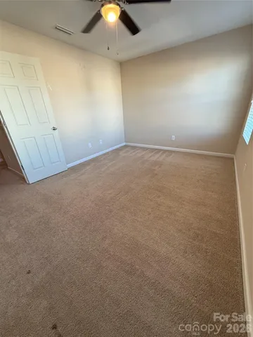 an empty room with a ceiling fan and window