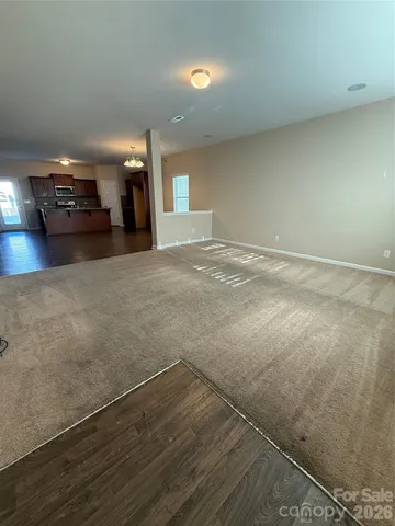 an empty room with stairs and wooden floor