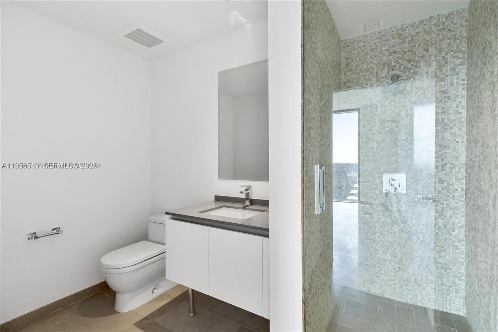 88 Southwest 7th Street, Unit 2104 Miami, FL 33130 - Photo 21 of 50 a bathroom with a granite countertop sink toilet a mirror and shower