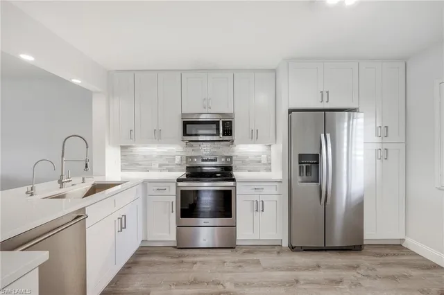 a kitchen with sink a stove and cabinets