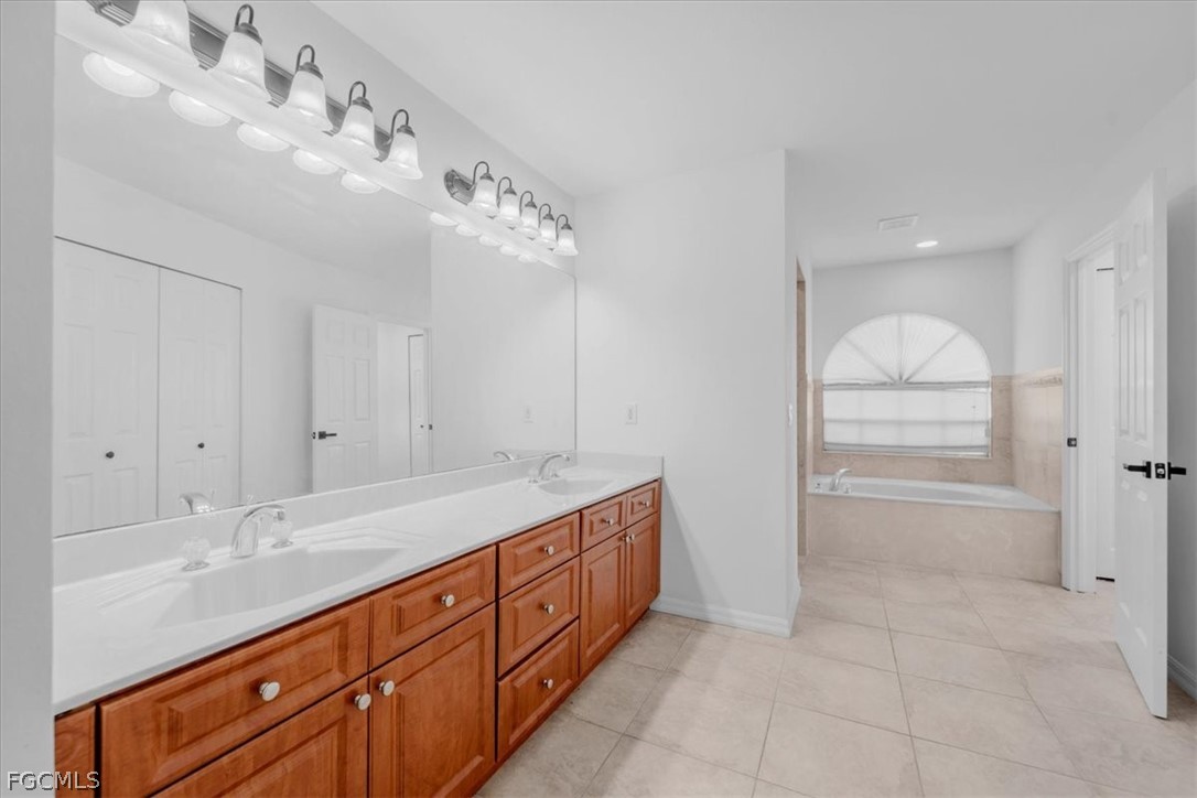 430 South Datil Street Clewiston, FL 33440 - Photo 13 of 33 a spacious bathroom with a granite countertop sink a mirror and a vanity