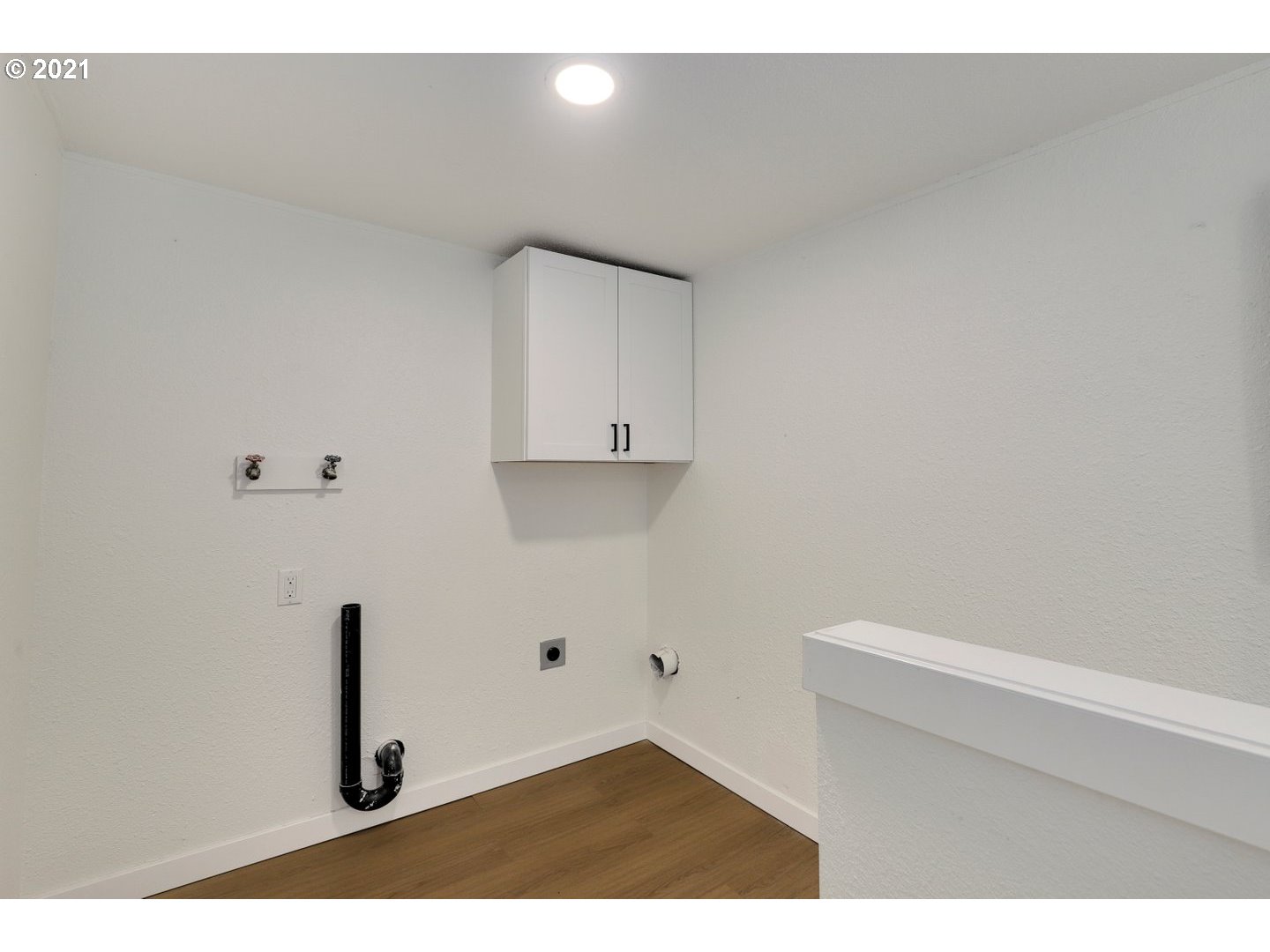 817 Highland Street Ridgefield, WA 98642 - Photo 23 of 27 a kitchen with white cabinets and a wooden floor