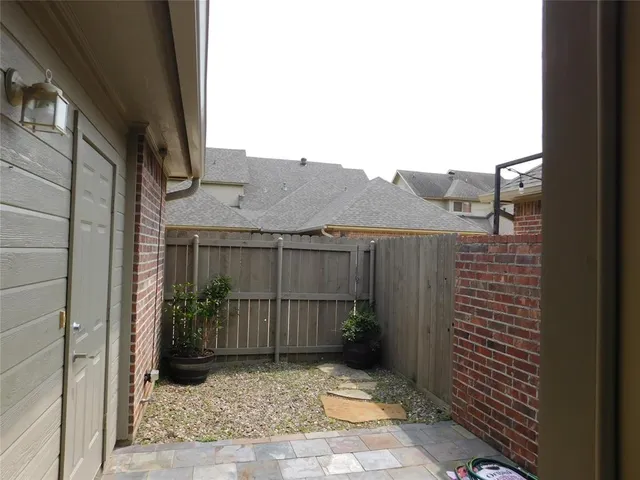 a view of a brick house with a small yard