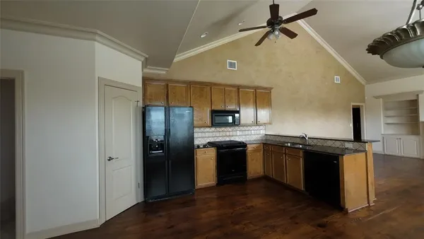 a kitchen with stainless steel appliances granite countertop a refrigerator a sink a stove and island