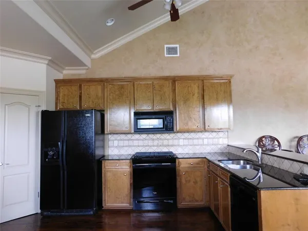 a kitchen with granite countertop stainless steel appliances and wooden cabinets