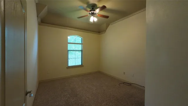 an empty room with a window and a fan