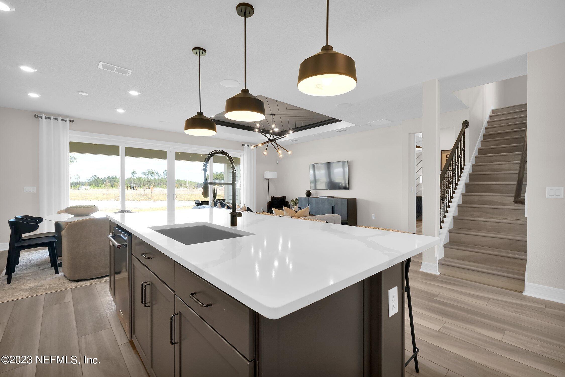 306 Shortleaf Lane Yulee, FL 32097 - Photo 12 of 35 a kitchen with stainless steel appliances granite countertop a sink a stove and a wooden floors