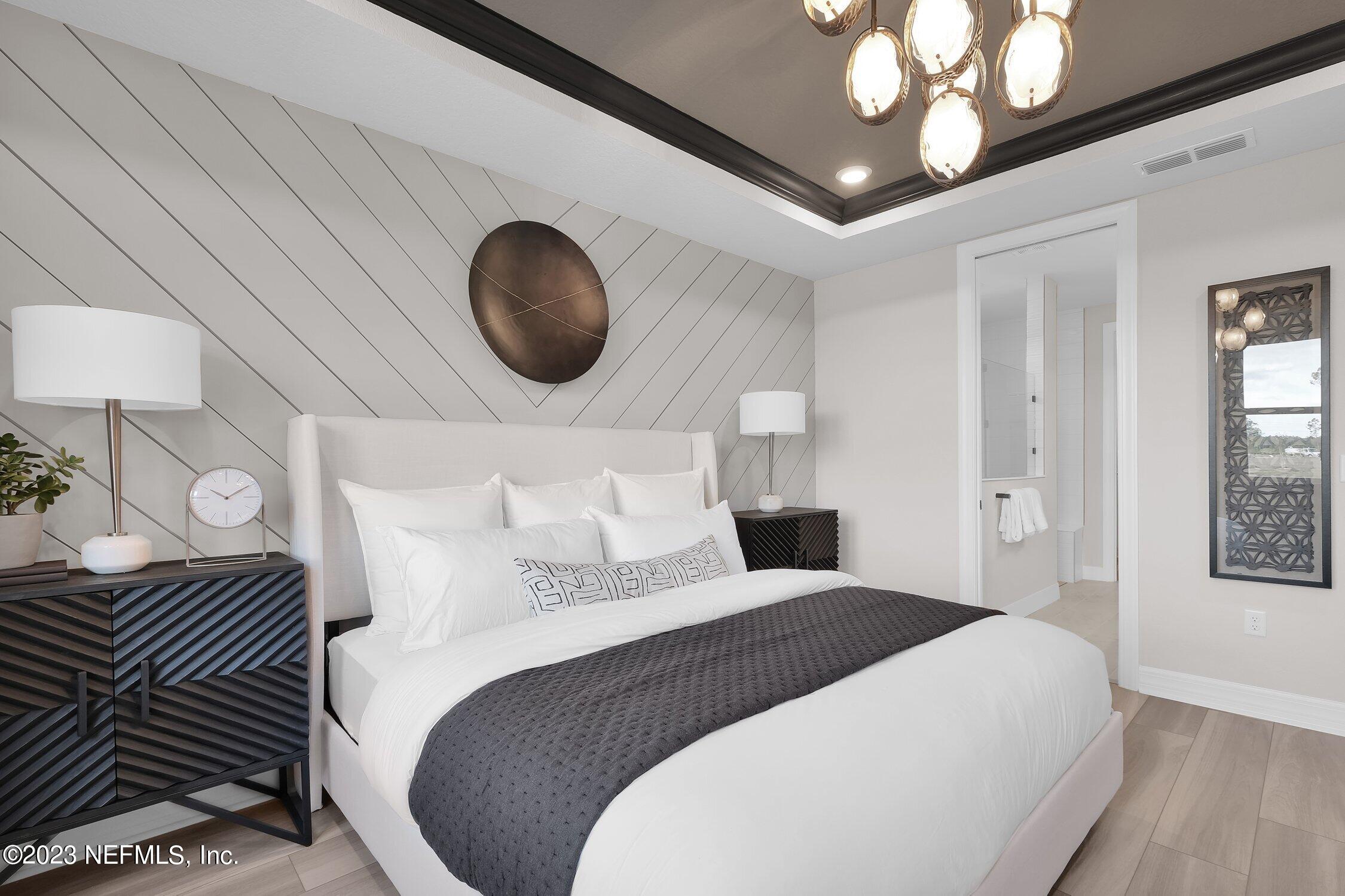 306 Shortleaf Lane Yulee, FL 32097 - Photo 18 of 35 a bedroom with a large bed and a chandelier