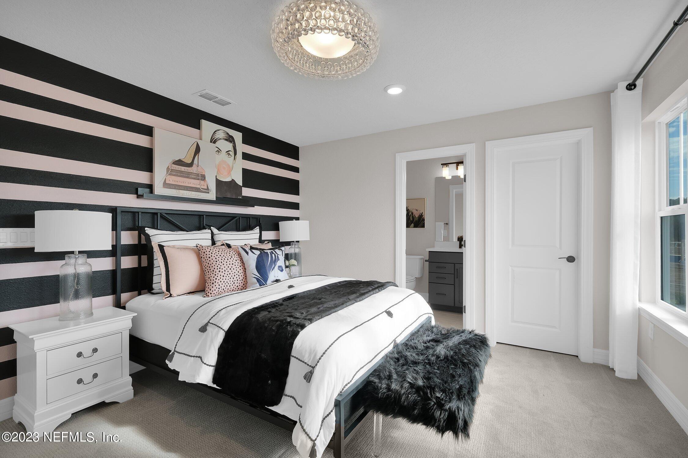 306 Shortleaf Lane Yulee, FL 32097 - Photo 24 of 35 a bedroom with a bed and a chandelier