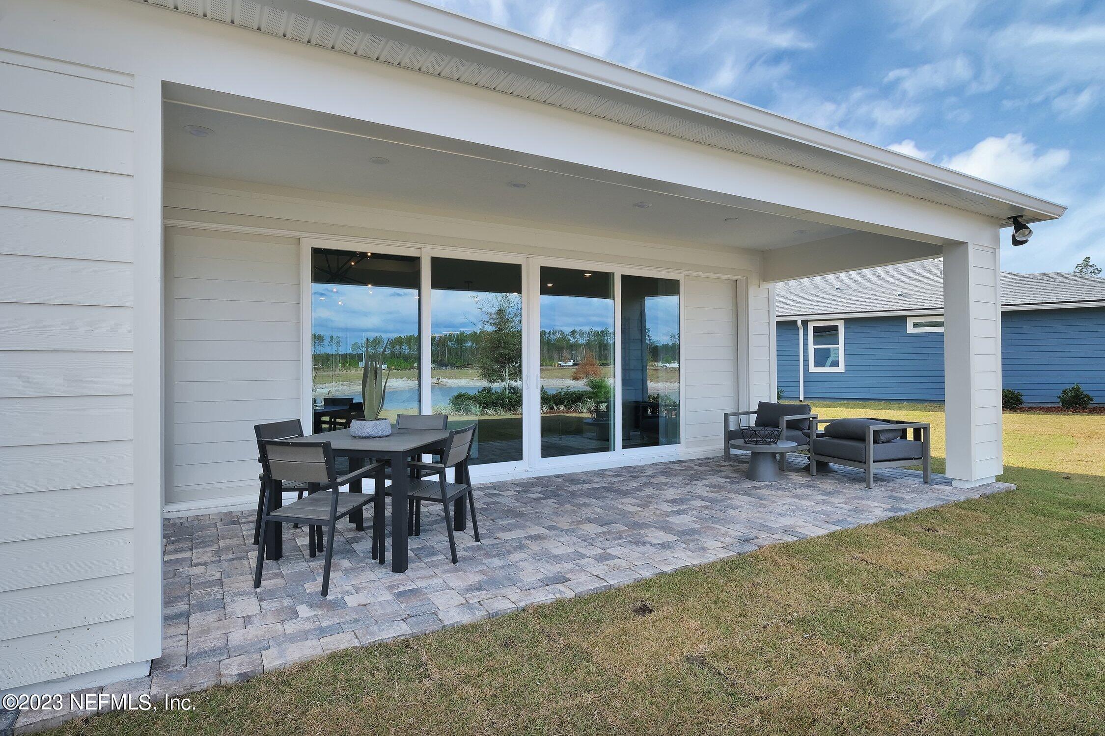 306 Shortleaf Lane Yulee, FL 32097 - Photo 30 of 35 a view of a porch with chairs and floor to ceiling window
