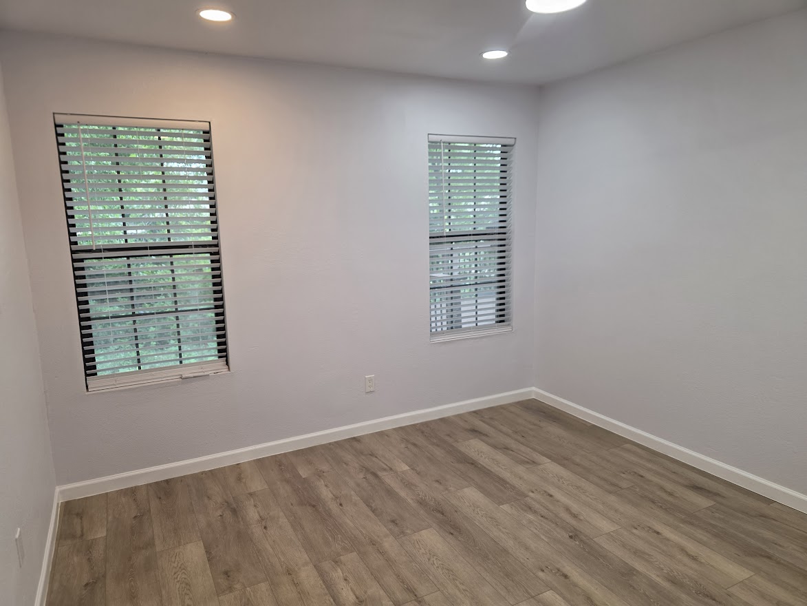 4803 Peach Grove Road Austin, TX 78744 - Photo 7 of 22 an empty room with wooden floor and windows