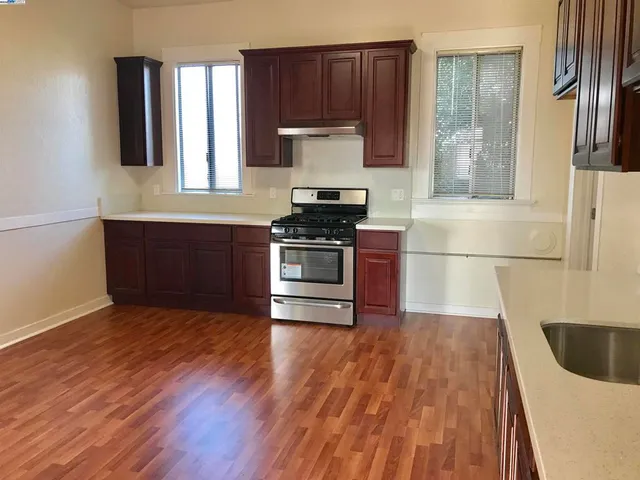 a kitchen with granite countertop wooden floors and stainless steel appliances