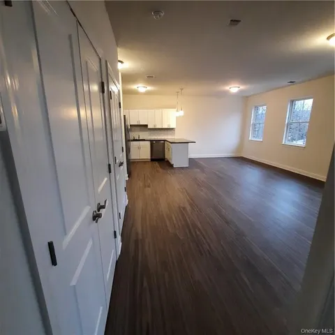 a kitchen with stainless steel appliances granite countertop a refrigerator a sink dishwasher a stove and white countertops with wooden floor