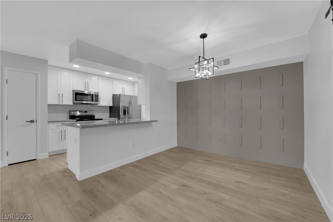 8101 West Flamingo Road, Unit 2152 Las Vegas, NV 89147 - Photo 11 of 45 A contemporary kitchen and dining space featuring an open-concept layout and elegant fixtures.
