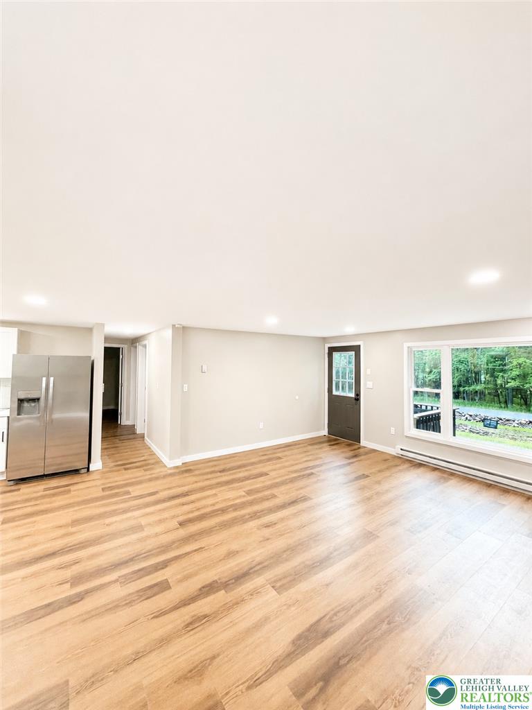 182 Mountain Road Albrightsville, PA 18210 - Photo 12 of 17 Natural wood-look flooring and generous windows define this open living space.