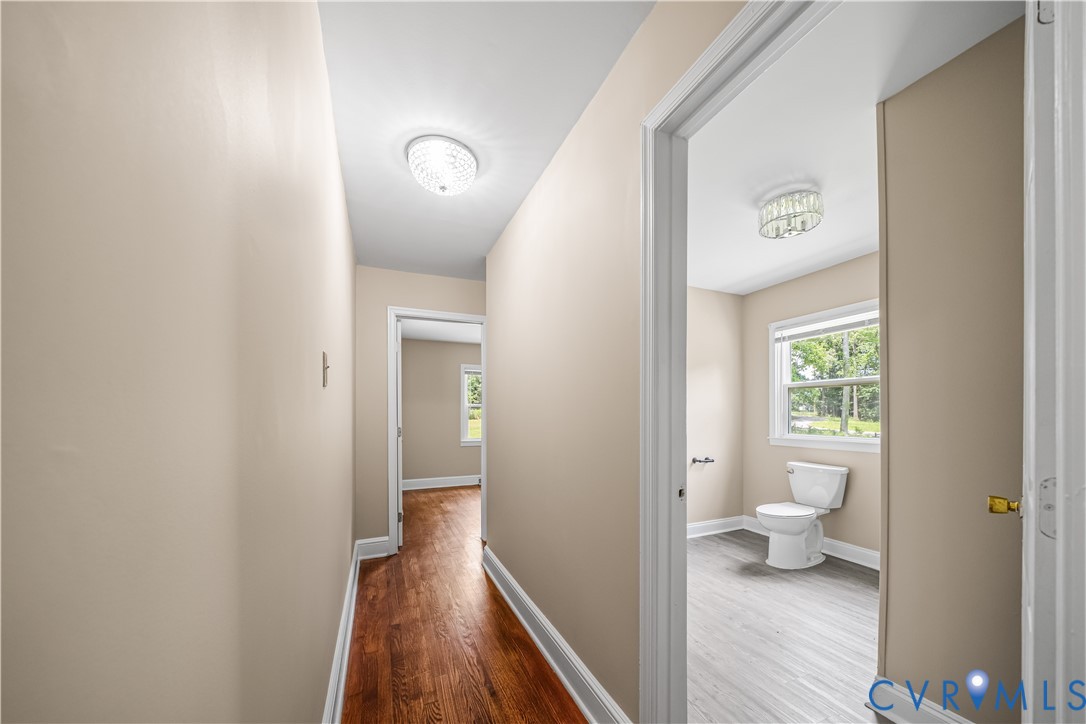 3179 Sandy Hook Road Sandy Hook, VA 23153 - Photo 15 of 36 a view of a hallway with wooden floor and a bathroom