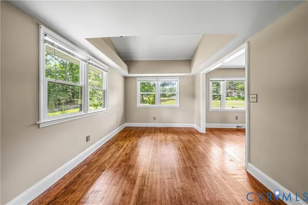 an empty room with windows and fireplace