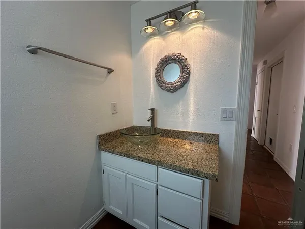 a bathroom with a granite countertop sink and a mirror
