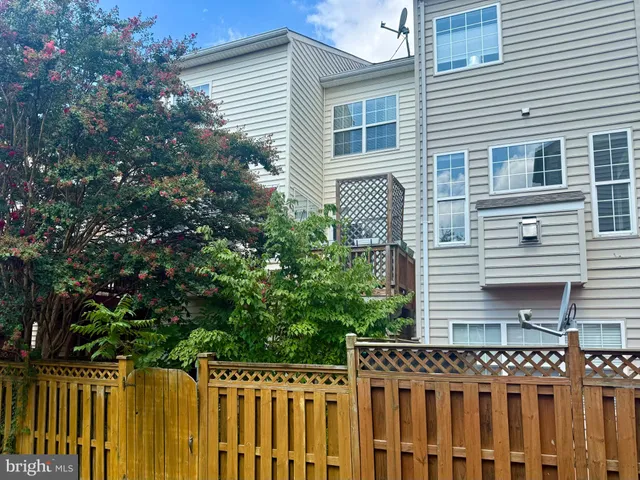 a view of a house with a small yard and wooden fence