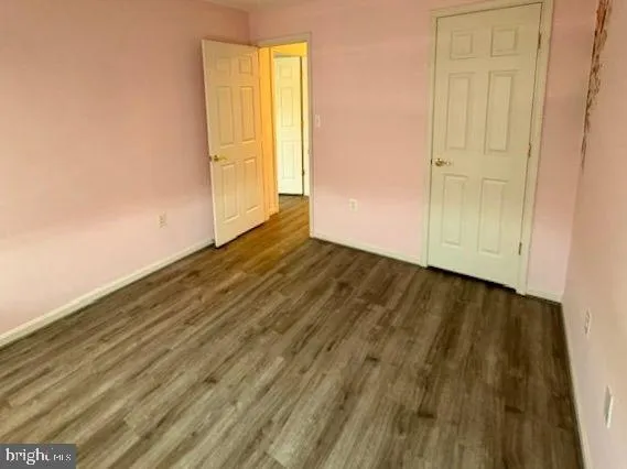 an empty room with wooden floor and closet